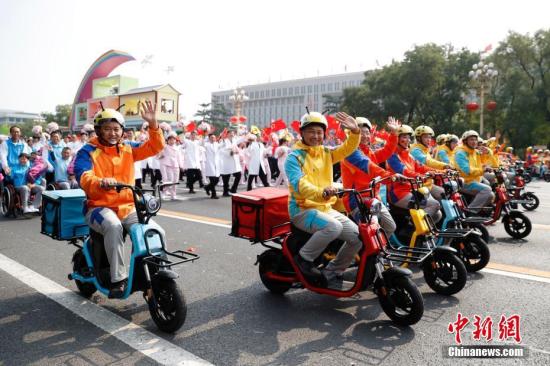 10月1日上午，庆祝中华人民共和国成立70周年大会在北京天安门广场隆重举行。图为群众游行中的“快递小哥”。中新社记者 韩海丹 摄